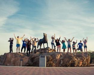 People cheering with wolf statue